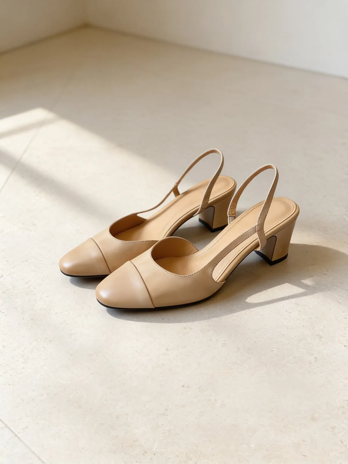 The Long Weekend Slingback in almond leather on limestone.